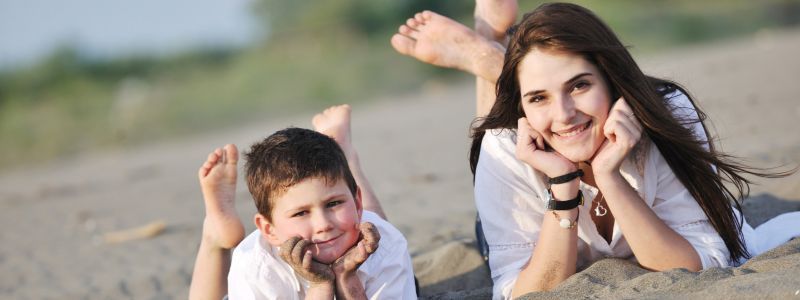 Mama e hijo tumbados en playa